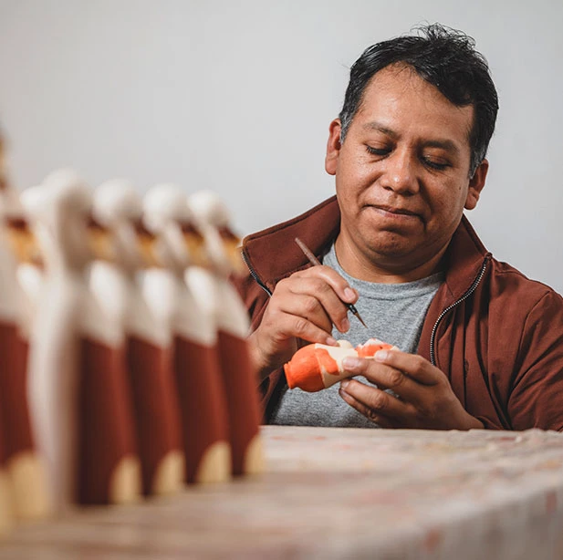 Gabriel dando bienvenida a visitante enseñando un producto