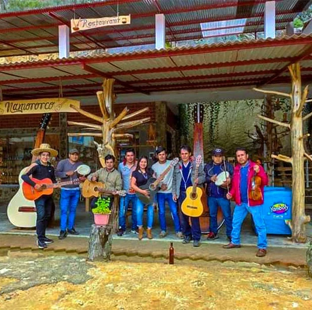Despidiendo a visitantes Turistas apreciando el proceso de elaboración de  una guitarra
