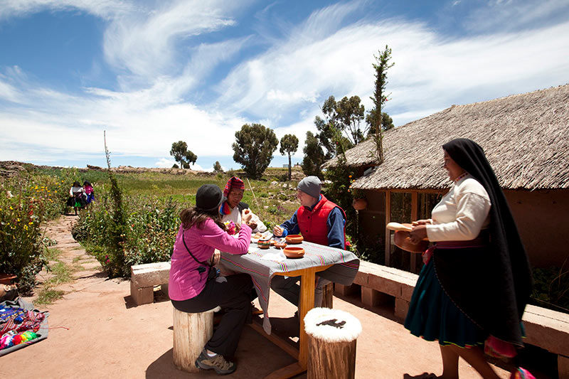 Turismo en el Perú. Pobladores le dan comida a turistas